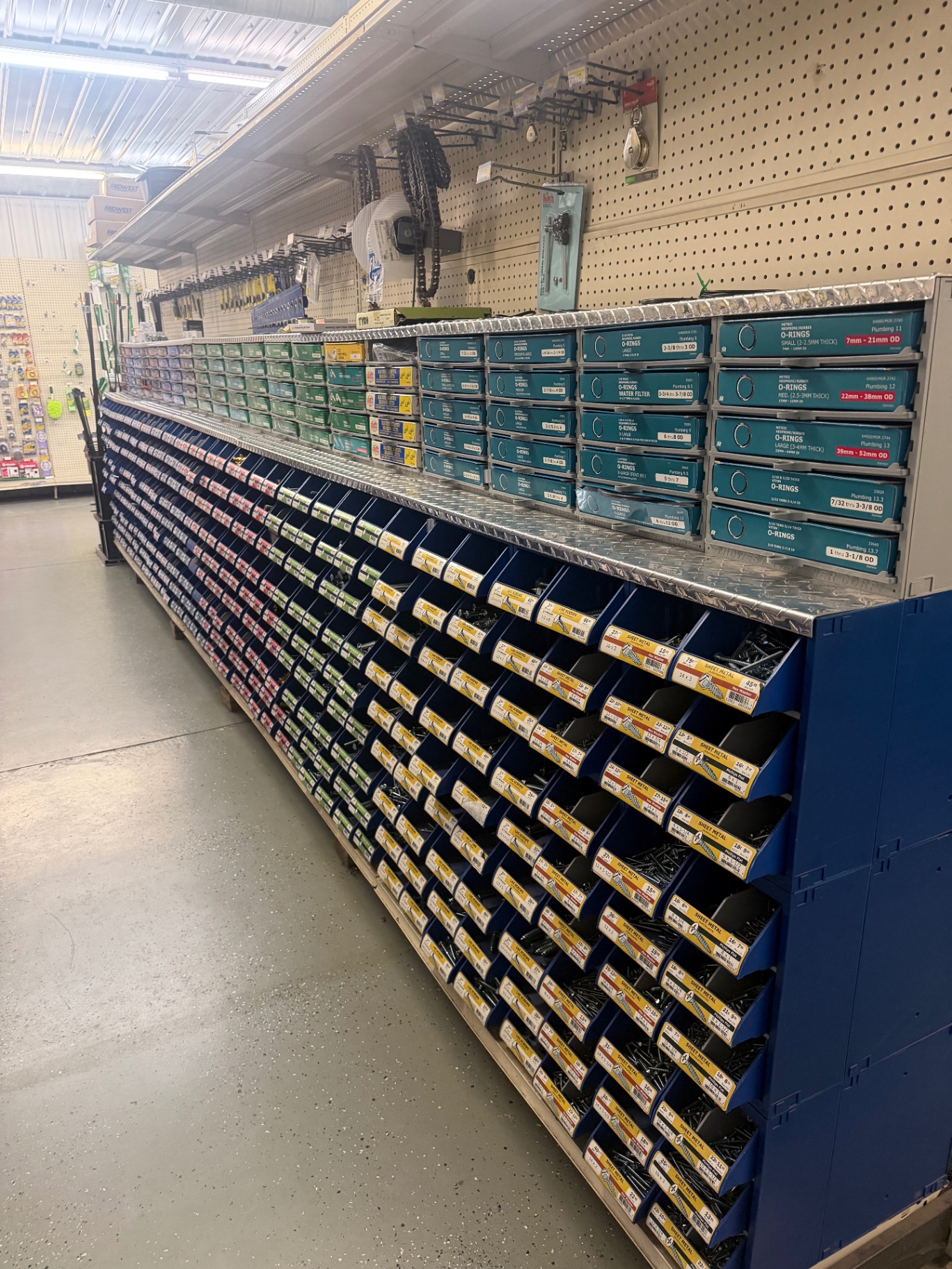 Blue parts bins filled with screws, bolts and nuts labeled by size