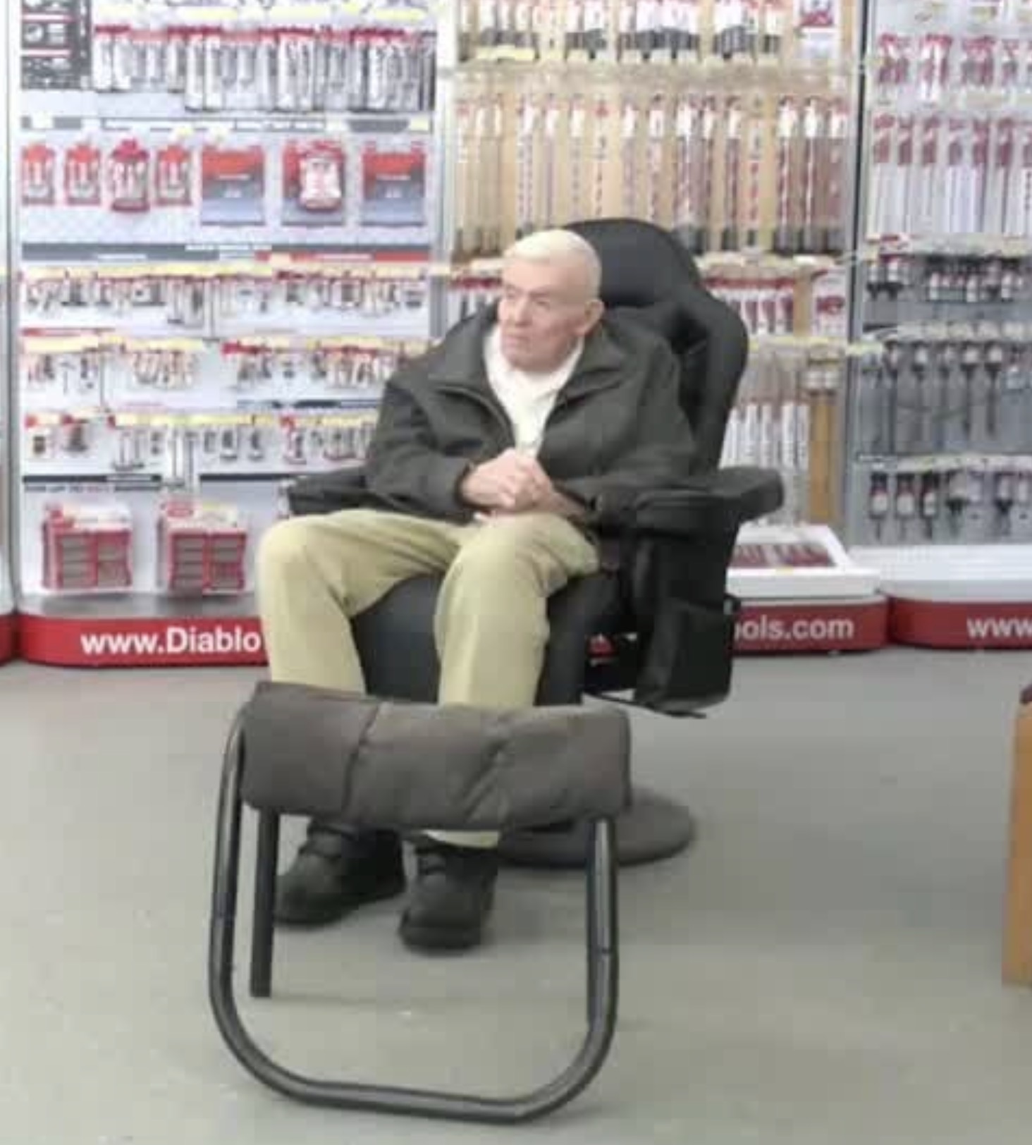 Jim Stockton, founder of Town & Country Hardware, sitting in the store among hardware displays and tool accessories